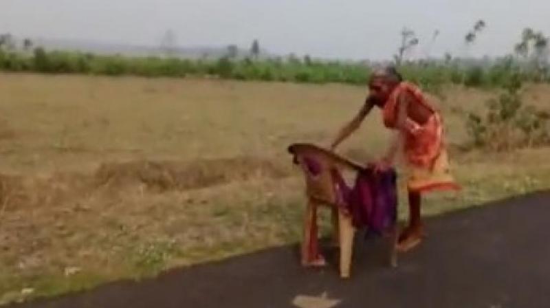  Elderly woman reached the bank to collect pension with the help of a chair in scorching sun